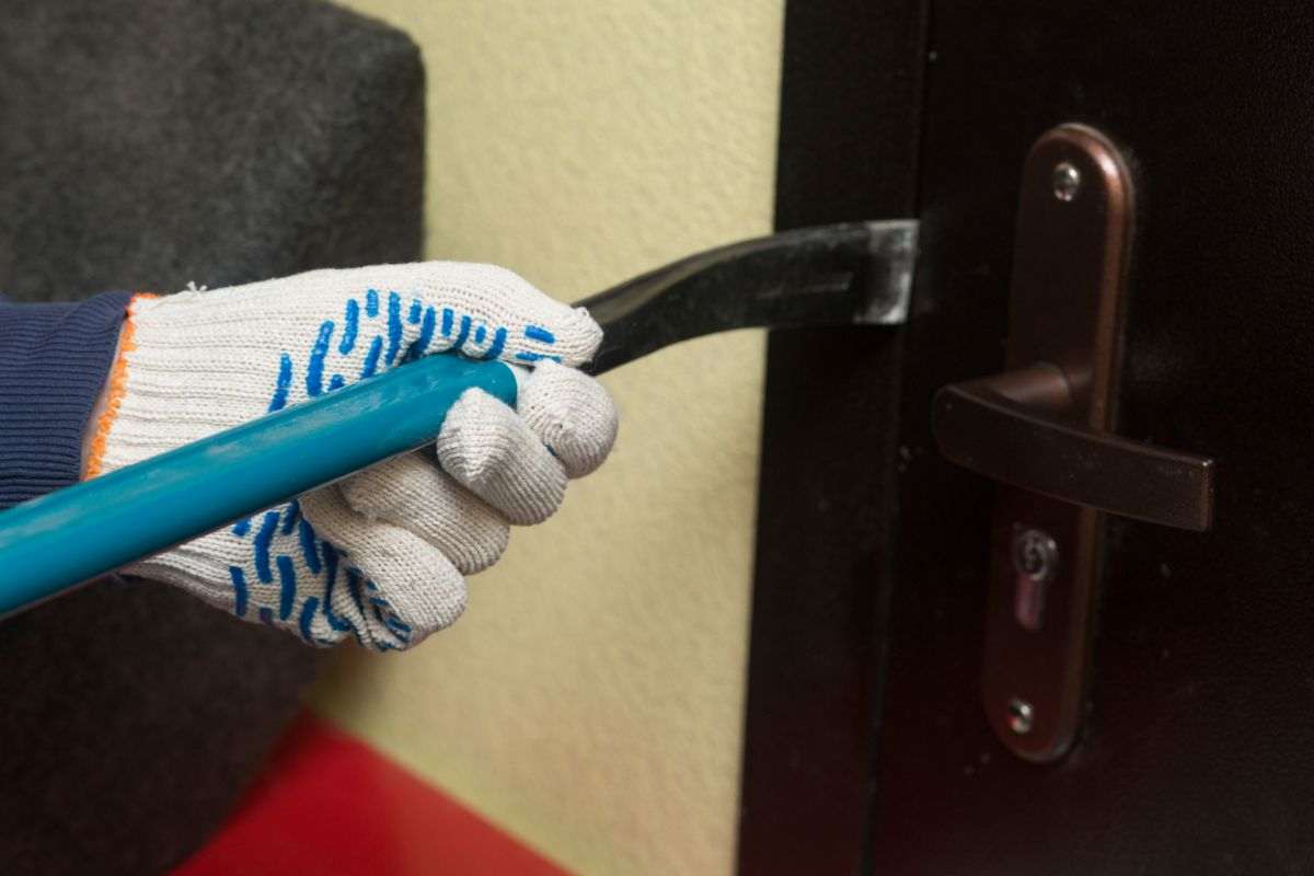 ladro che scassina una porta