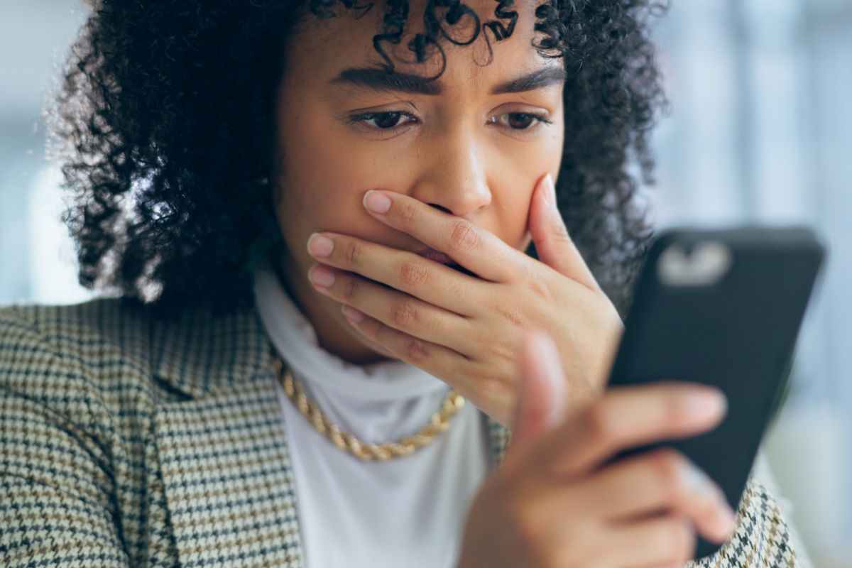 donna preoccupata guarda smartphone