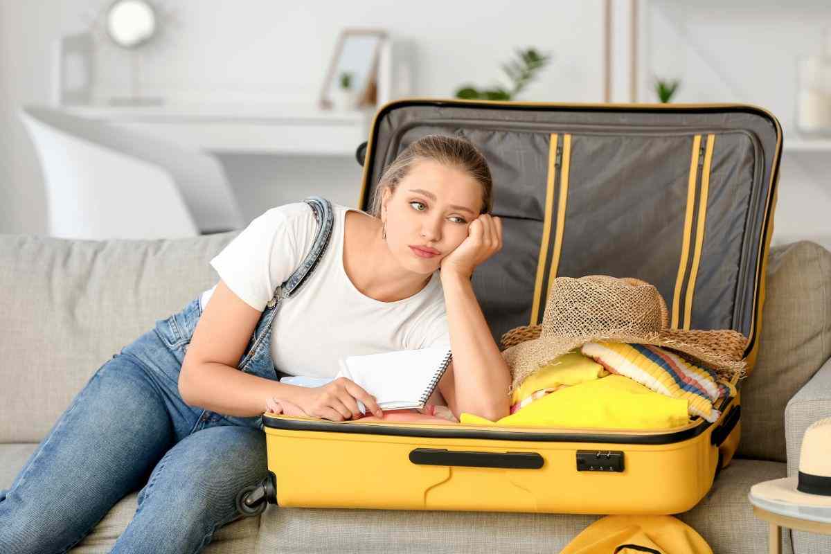 donna triste valigia aperta