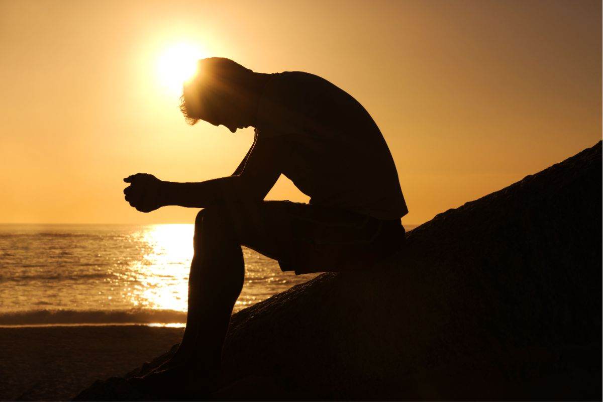 uomo triste tramonto mare