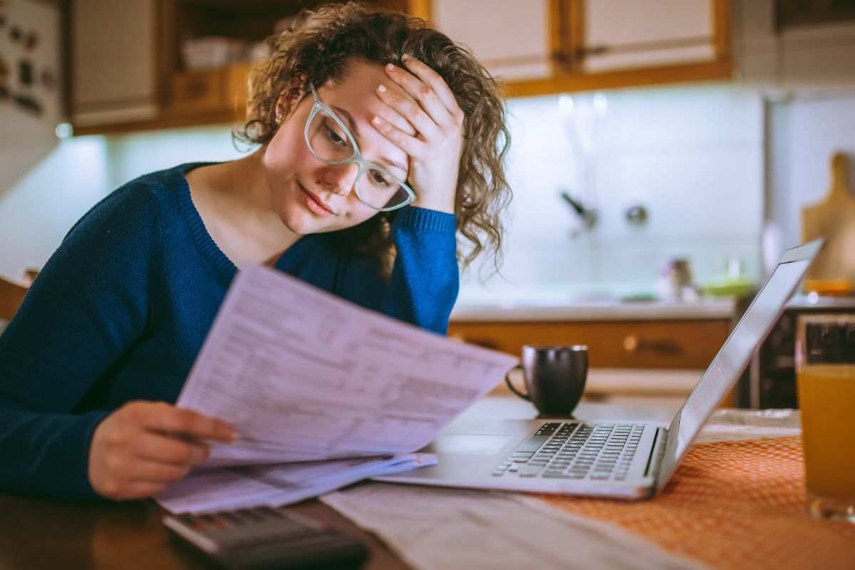 donna preoccupata legge documento