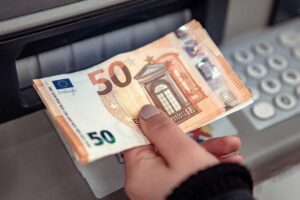 persona che preleva 50 euro al bancomat
