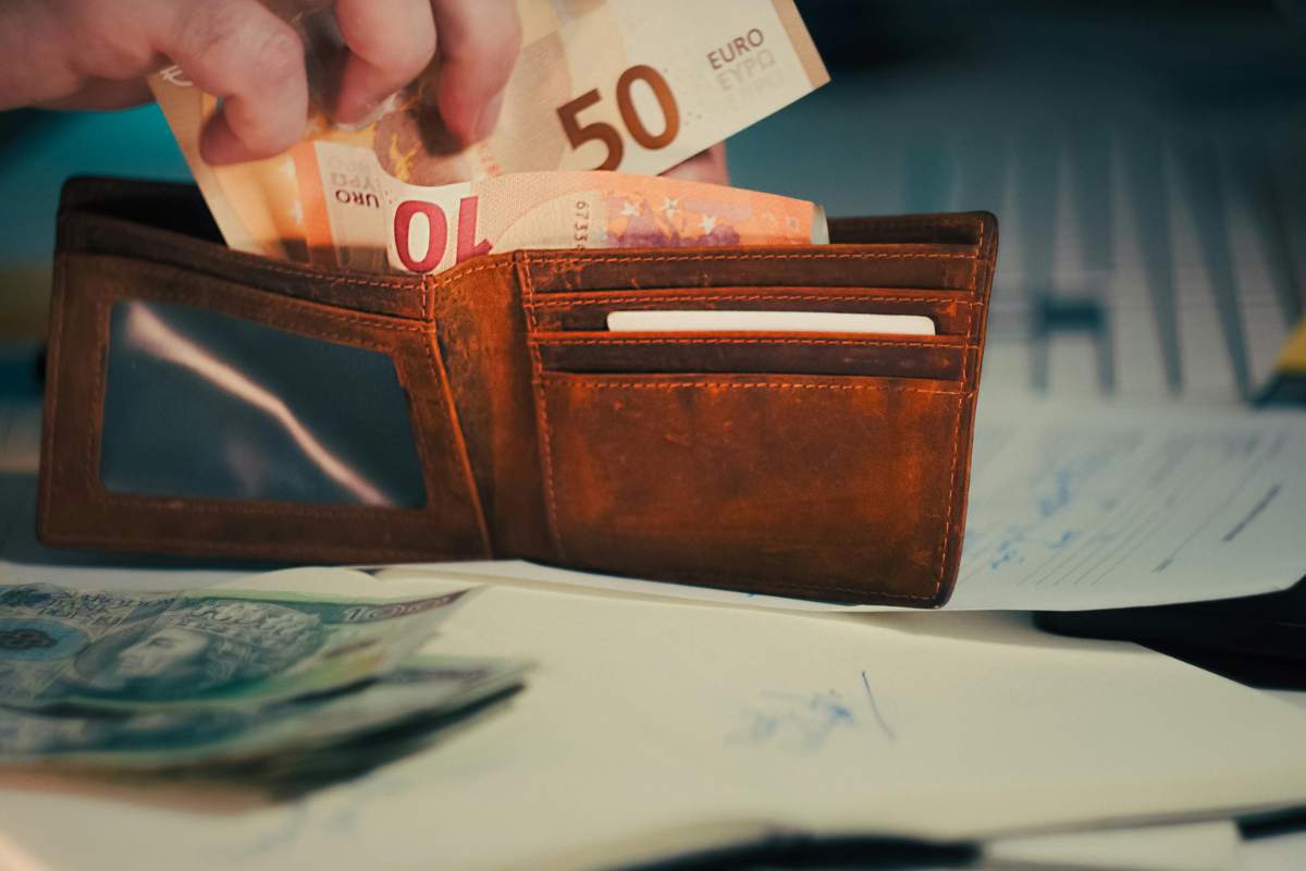 persona mette dei soldi nel portafogli