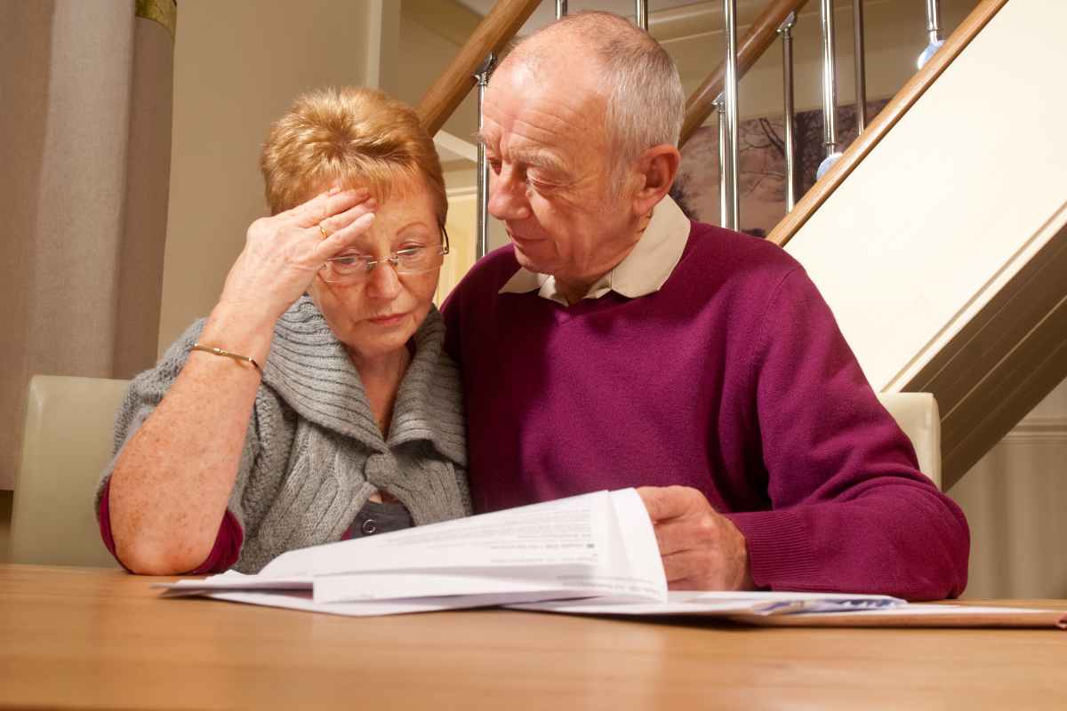 coppia anziana che legge dei documenti