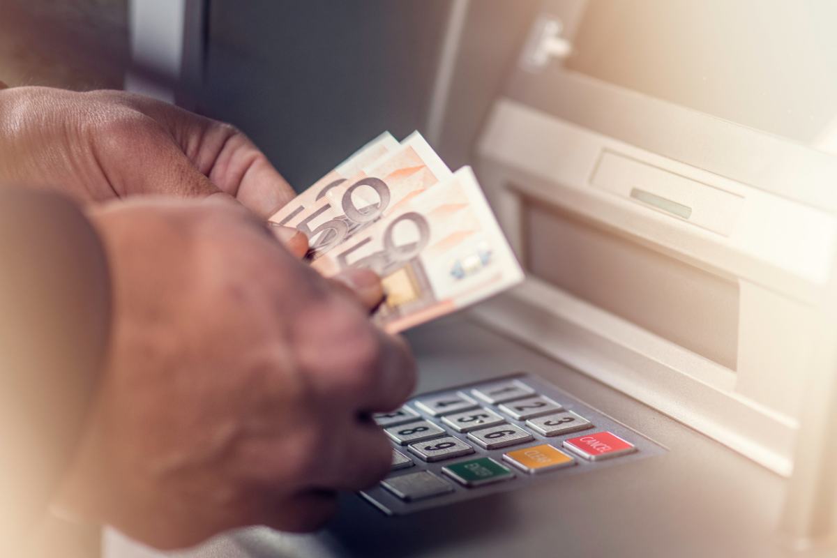 persona che preleva soldi al bancomat
